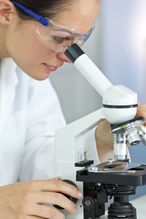 woman looking through microscope